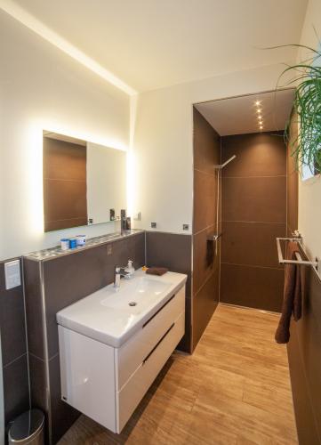 Funktional und komfortabel: Das Bad im Erdgeschoss mit bodengleicher Dusche.Foto: Helma Eigenheimbau AG